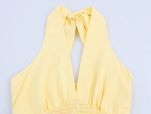 Vue détaillée du décolleté dos nu à rayures jaunes avec nœud et taille élastique froncée