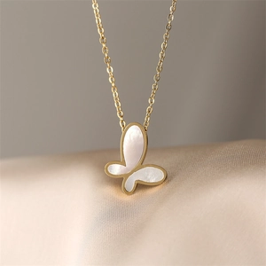 Macro shot of gold butterfly pendant with iridescent mother of pearl on satin