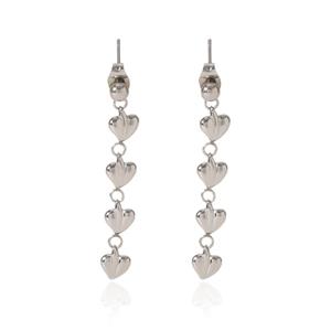 Détail de boucles d'oreilles cœur en acier argenté avec un reflet miroir élégant