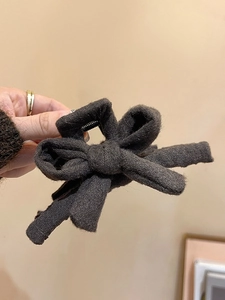 Gros plan sur la pince à cheveux nœud marron foncé avec texture tricotée et ressort