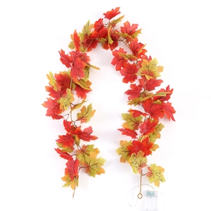 Detail view of artificial maple leaf garland with copper wire LED lights for autumn decor