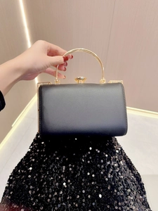 Detail of elegant black evening clutch with golden metal handle and secure top lock