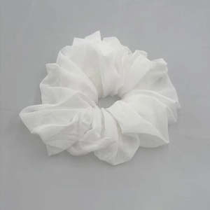 Detail view of a white translucent chiffon hair scrunchie with soft fabric texture