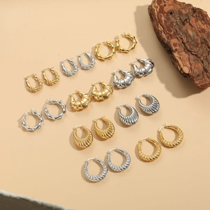Detail verschiedener gold- und silberfarbener Creolen mit Akzent aus Naturholz