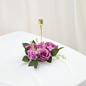 Detailed view of elegant golden metal candle holder with purple rose and leaf wreath decor