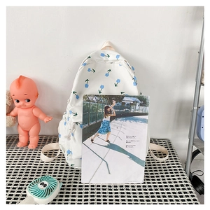 Close-up of white nylon floral backpack with blue tulips and side pocket storage