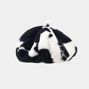 Détail du béret en peluche à motif vache montrant la texture douce de la fausse fourrure