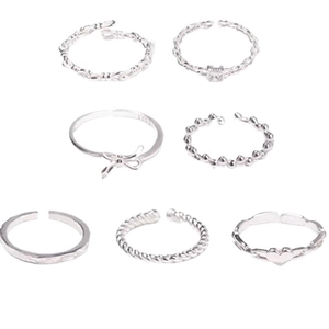 Set of 7 minimalist silver metal rings featuring twist, chain, and bow designs for women