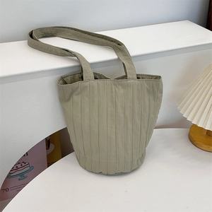 Detailopname van een grijsgroene geplooide stoffen shopper met verticale textuur en stijl