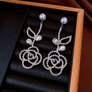 Exquisite long silver tassel earrings with diamond flowers and pearls on black velvet display