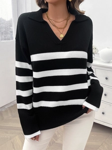 Dettaglio di un maglione a maglia a righe bianche e nere con colletto a polo classico
