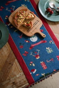 Detailed blue Christmas table runner with festive embroidery on a rustic wooden table