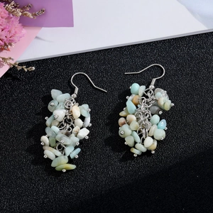 Detailed macro view of handmade natural crystal chip tassel earrings with silver hooks