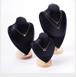 Detail of matte black portrait bust jewelry stands with solid wood circular bases