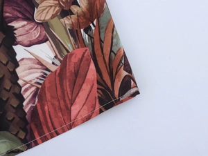 Close-up of tropical leaf print fabric with detailed stitching on a maxi dress hem