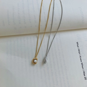 Detail of gold and silver pearl pendant necklaces on a vintage book background