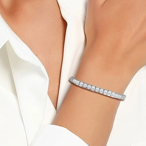 Macro detail of silver tennis bracelet with square zircons worn on wrist