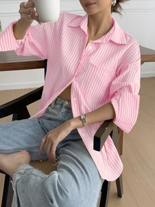Close-up of pink and white striped long-sleeve shirt with buttons and turn-down collar