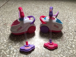 Detail view of pink and purple toy vacuum cleaners from the Kids Cleaning Set for children