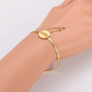 Gold flat snake chain bracelet featuring 2024 engraved round disc on female wrist