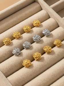 Detail shot of 18k gold and silver rose flower stud earrings in a jewelry box