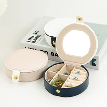 Detail view of round portable jewelry box with mirror and partitioned ring slots
