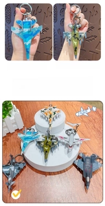 Macro detail of mini fighter jet keychains in various camouflage colors and metal clasp