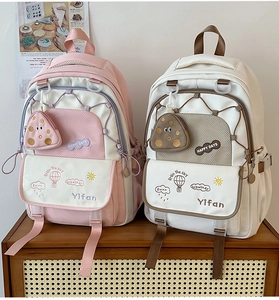 Detail of waterproof nylon backpacks with embroidery and hanging triangle coin purses