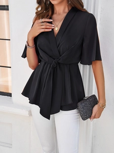 Détail de l'élégant décolleté en V et du nœud à la taille sur ce haut noir femme