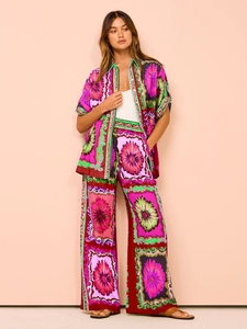 Detail of vibrant floral print button-down shirt and wide-leg pants silky summer set