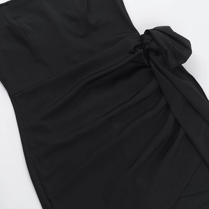 Close-up of black dress featuring twist waist detail and premium knit fabric texture