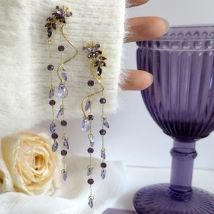 Détail de boucles d'oreilles élégantes en glycine violette et pampilles papillon