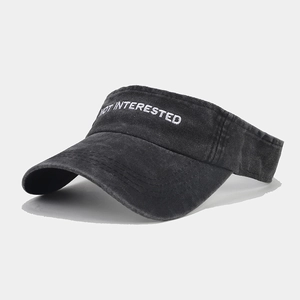 Detail of NOT INTERESTED embroidery on washed denim visor hat with distressed finish