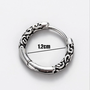 Detail showing a silver steel hoop earring with embossed pattern and 1.2cm size mark