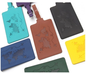 Close-up of leather luggage tags with world map embossing and adjustable buckle straps