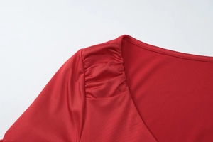 Close-up of ruched shoulder detail and red fabric texture on this stylish V-neck dress