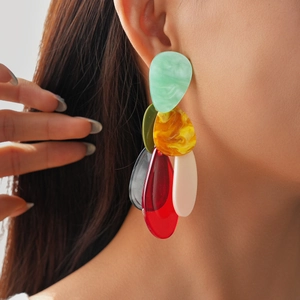 Detail of long layered acrylic drop earrings in colorful smudge patterns on a model