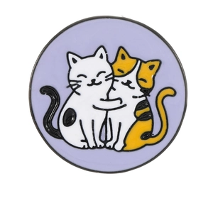 Round metal enamel pin featuring two hugging cartoon cats on a light purple background