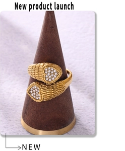 Detail of adjustable gold ring featuring snake scales texture and zircon hearts