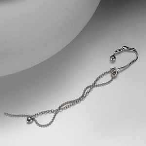 Detail of S925 sterling silver ear cuff with delicate chain and solid heart pendant