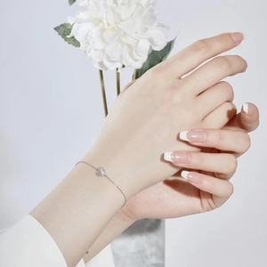 Close-up of S925 sterling silver heart bracelet with cubic zirconia on female wrist