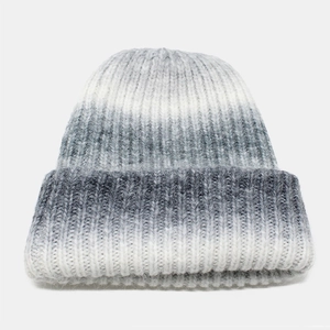 Detail of grey and white gradient knitted beanie showing soft ribbed texture and plush yarn