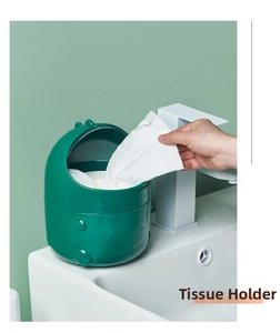 Detail of green dinosaur desktop tissue box holder placed on a modern white bathroom sink