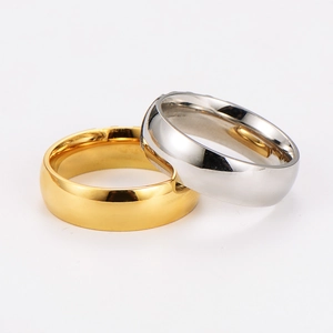 Close-up of polished gold and silver stainless steel rings with subtle striped patterns