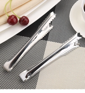 Macro shot of silver stainless steel ice tongs with serrated edges for picking sugar