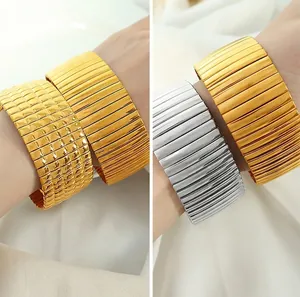 Detailansicht breiter strukturierter Metallmanschetten in Gold und Silber mit Längsrillen