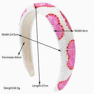 Detail showing dimensions of a white beaded headband with pink and red heart patterns