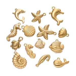 Macro view of 14 gold plated stainless steel ocean charms including starfish and shells