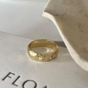 Close-up of S925 silver irregular ring with golden hammered texture and hallmark