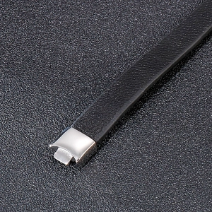 Detailed close-up of black braided leather texture and silver stainless steel clasp